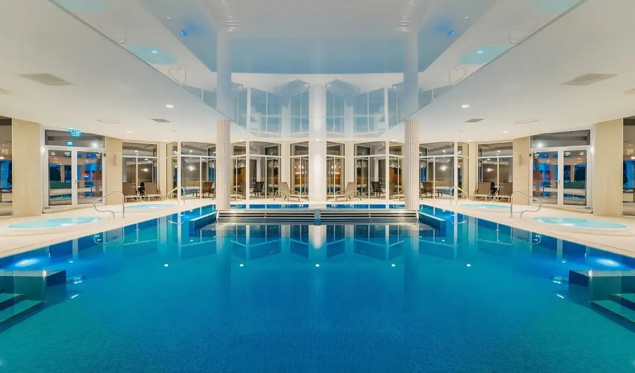 Luksusowy basen z podświetlanymi jacuzzi i leżakami, idealny na relaks w Crystal Mountain Aquapark.