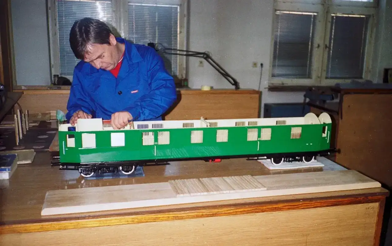 Modelarz składa zielony wagon kolejkowy w Jeleniej Górze.