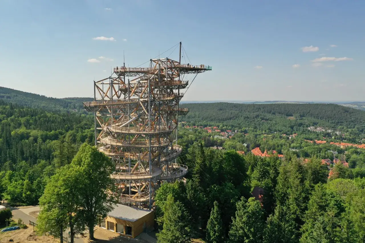 Drewniana wieża widokowa z krętymi schodami, oferująca wspaniały sky walk nad lasem i miasteczkiem.