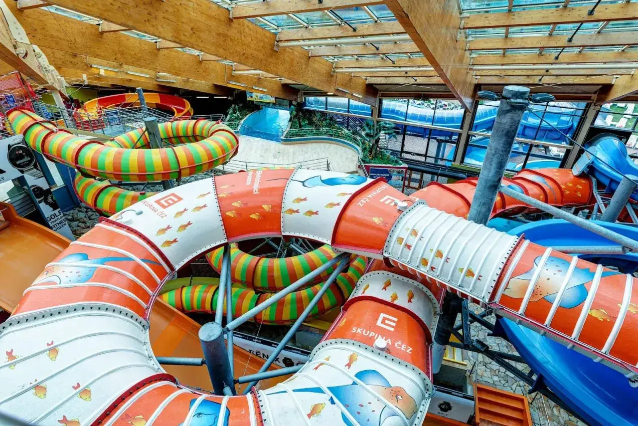 Kolorowe zjeżdżalnie wodne w czeskim aquaparku, z rybkami i napisem