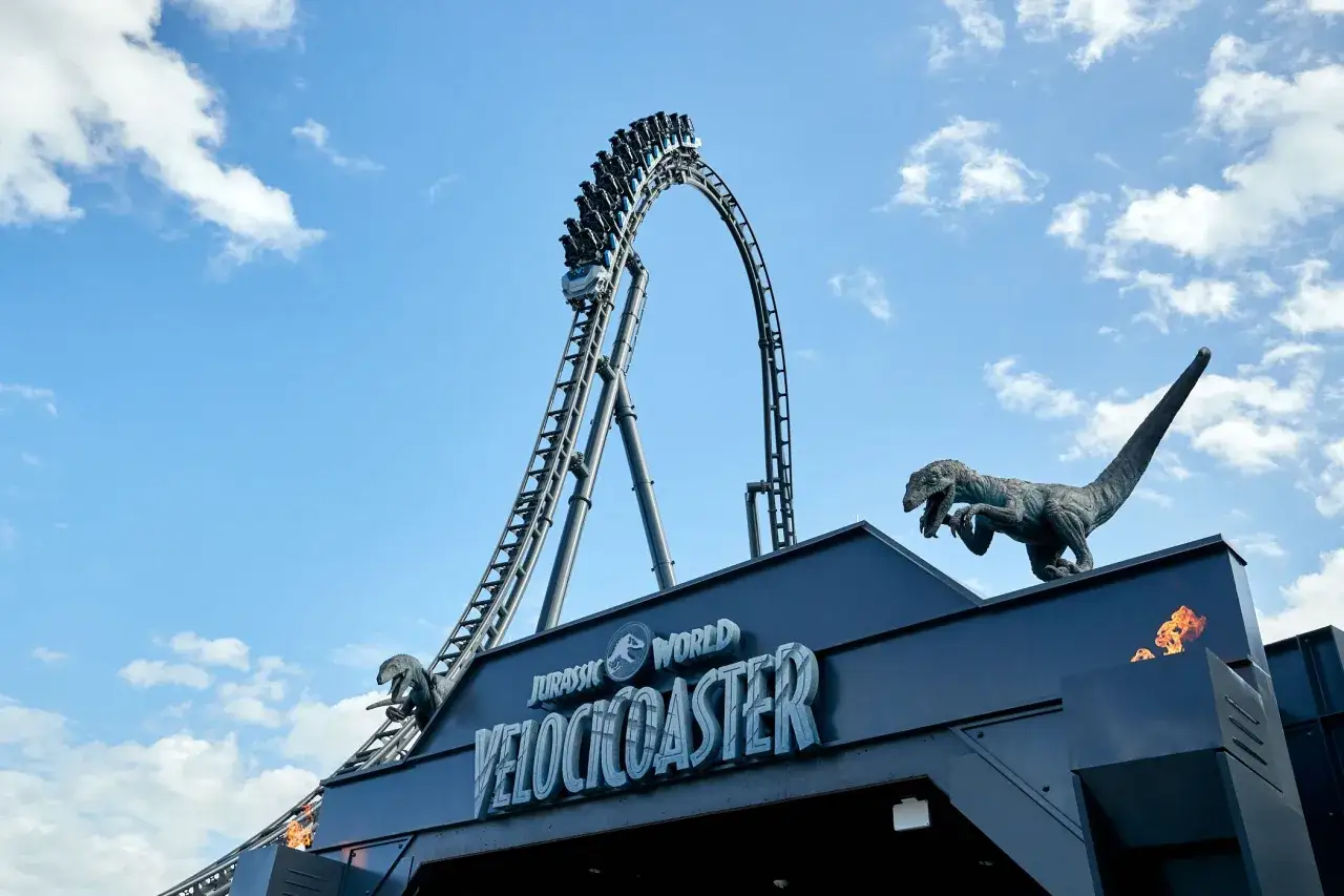 Kolejka górka w Jurassic World Park, z dinozaurem i płomieniami.