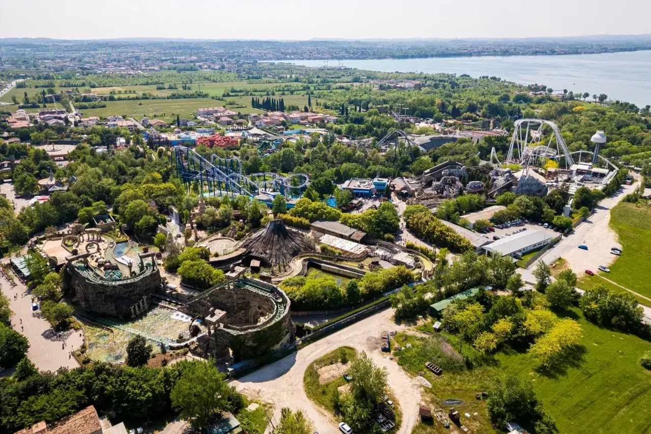 Widok z lotu ptaka na największy park rozrywki w Europie, z kolejkami górskimi, wodnymi atrakcjami i bujną zielenią.