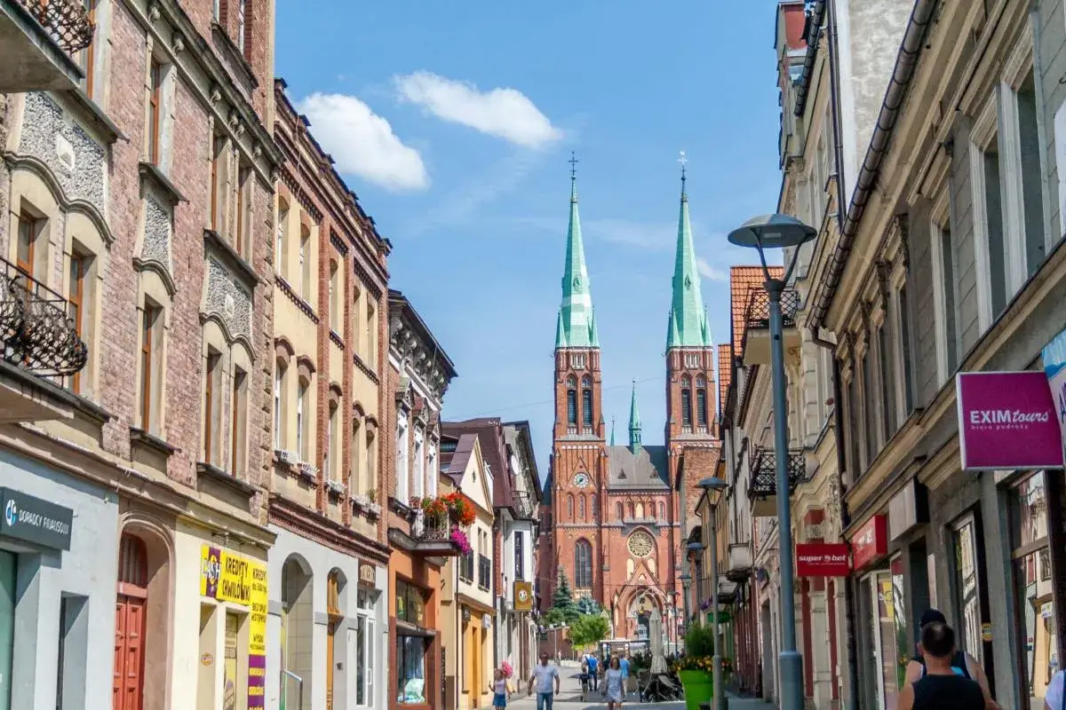 Ulica w Rybniku z widokiem na kościół, pełna sklepów i kawiarni. To świetne miejsce na spacer i odkrywanie lokalnych atrakcji.