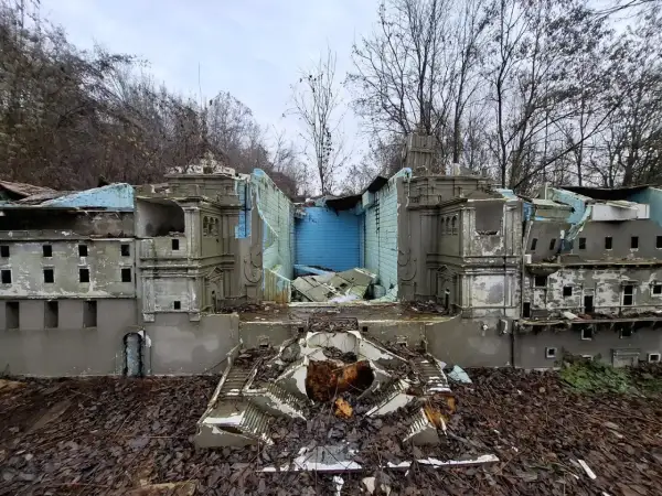 Zniszczony park miniatur sakralnych Złota Góra. Ruiny budowli, zniszczone schody i opadłe liście tworzą ponury krajobraz.