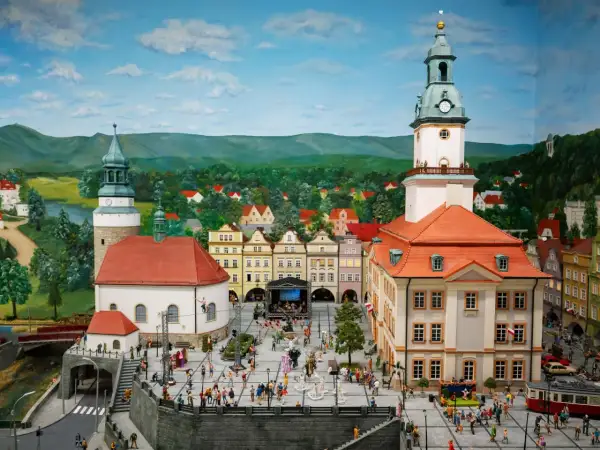 Miniaturowa kolejkowo scena z Jeleniej Góry, z ratuszem, kościołem i tłumem ludzi na rynku.
