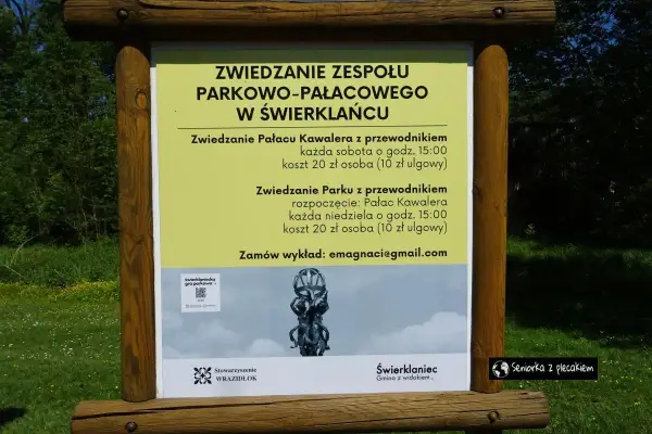 Tablica informacyjna o zwiedzaniu zespołu parkowo-pałacowego w Świerklańcu. Informacje o zwiedzaniu pałacu i parku z przewodnikiem, kosztach i godzinach.