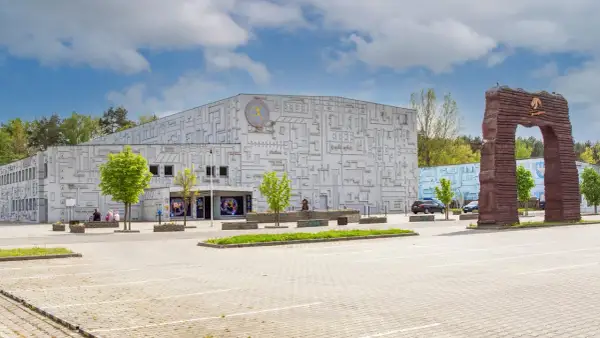 Fasada budynku z motywem labiryntu, symbolizująca park nauki i ewolucji człowieka. Obok monumentalny łuk.