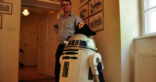 W muzeum Star Wars R2-D2 w wojskowym kapeluszu pozuje z mężczyzną.