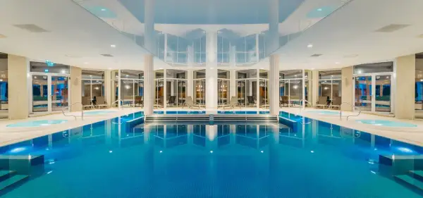 Wnętrze aquaparku Crystal Mountain z basenem, jacuzzi i leżakami.