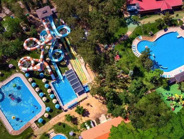 Widok z lotu ptaka na Santiago Aquapark: kolorowe zjeżdżalnie, baseny i zielone tereny rekreacyjne.