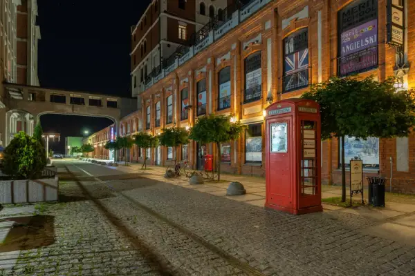 Nocny Żyrardów zachwyca. Czerwona budka telefoniczna i brukowana ulica tworzą niepowtarzalny klimat. To jedne z wielu żyrardowskich atrakcji.
