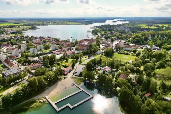 Malownicze miasteczko nad jeziorem, z plażą i basenem kąpielowym. Ryn oferuje wiele atrakcji, idealne miejsce na wypoczynek.