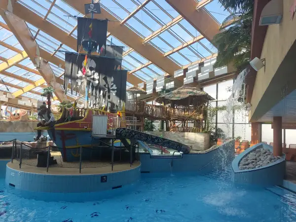 Wesoły aquapark w Czechach z pirackim statkiem, zjeżdżalniami i wodospadem. Idealne miejsce na rodzinną zabawę.