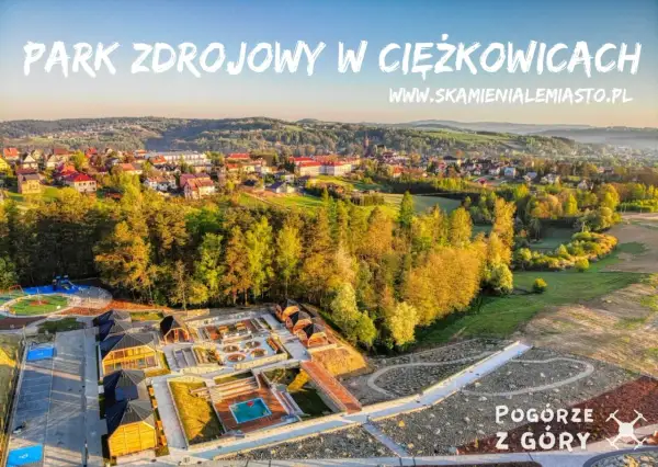 Park Zdrojowy w Ciężkowicach oferuje liczne atrakcje: plac zabaw, basen, sauny i ścieżki spacerowe. Widok z góry na malownicze Pogórze.